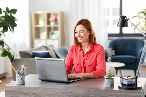 Щаслива жінка з ноутбуком працює в домашньому офісі — стокове фото