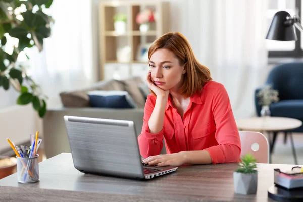 Mujer aburrida con el ordenador portátil que trabaja en casa oficina — Foto de Stock