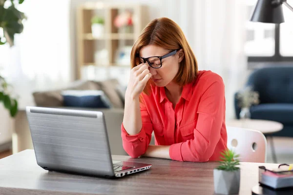 Скучающая женщина с ноутбуком работает в домашнем офисе — стоковое фото