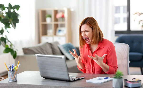 Wanita pemarah dengan laptop bekerja di kantor rumah — Stok Foto