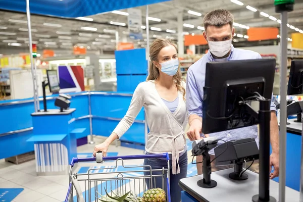 Couple in masks buying food at store cash register — Stock Photo, Image