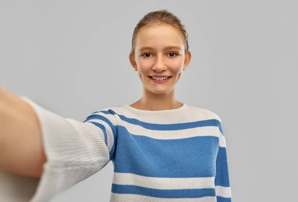 Lächelndes Teenager-Mädchen im Pullover macht Selfie — Stockfoto