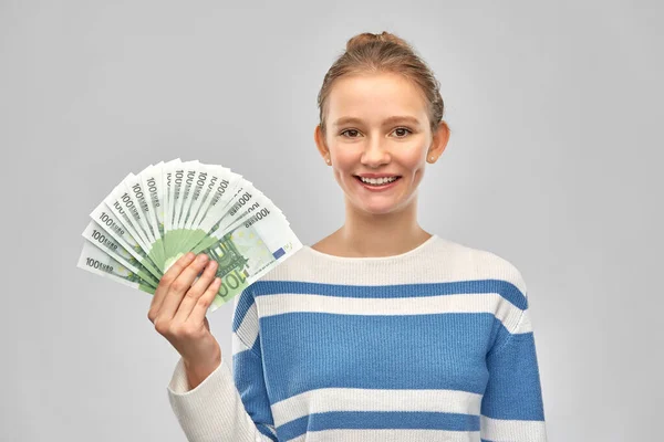 Adolescente sonriente con billetes en euros — Foto de Stock