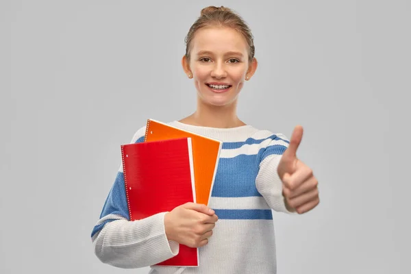 Sorrindo adolescente estudante menina mostrando polegares para cima — Fotografia de Stock