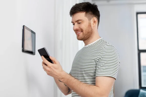 Glimlachende man met behulp van tablet computer in smart home — Stockfoto