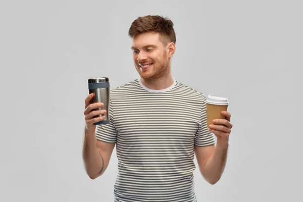 Man comparing thermo cup or tumbler and coffee cup — Stock Photo, Image