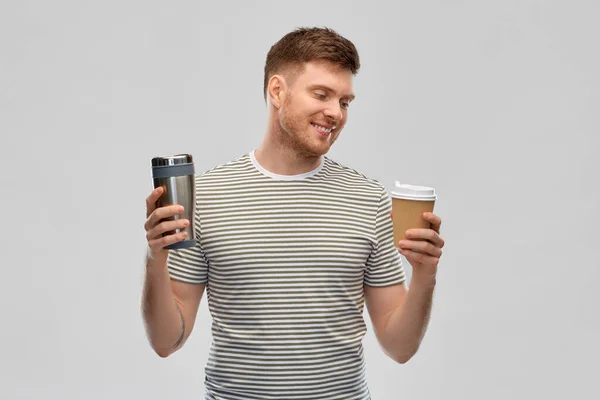 Hombre que compara la taza termo o vaso y taza de café —  Fotos de Stock