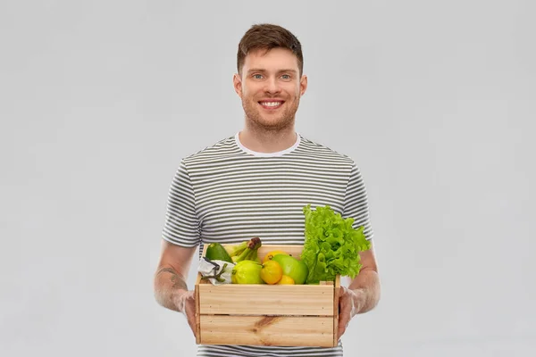 Счастливый улыбающийся человек с едой в деревянной коробке — стоковое фото