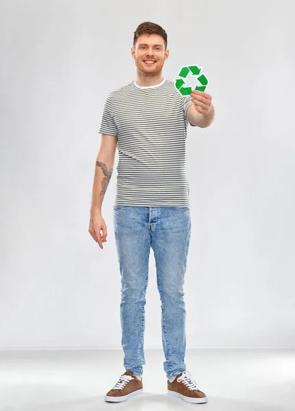 Joven sonriente sosteniendo letrero de reciclaje verde — Foto de Stock