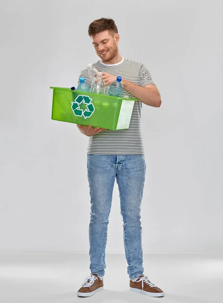 Sonriente joven clasificación de residuos de plástico — Foto de Stock