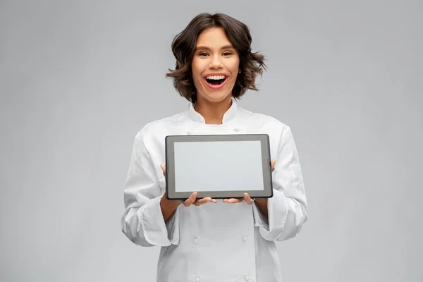 Chef femenino sonriente en toque con tablet — Foto de Stock