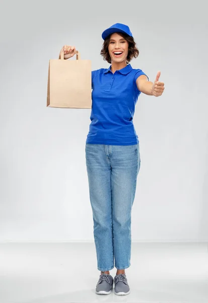 Entrega mujer con bolsa de papel mostrando los pulgares hacia arriba —  Fotos de Stock