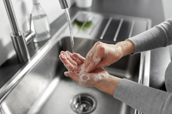Nő kezet mos folyékony szappannal a konyhában — Stock Fotó