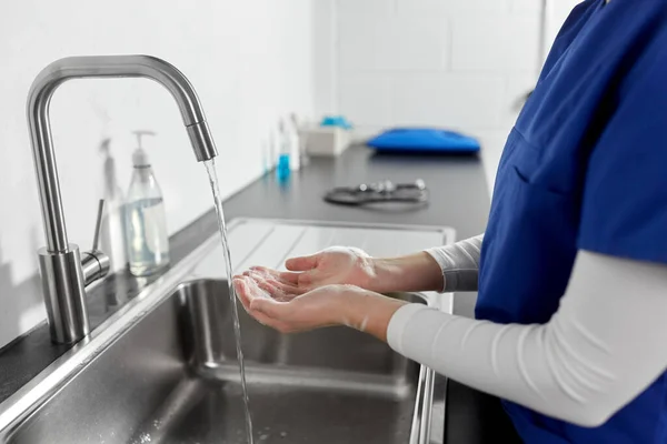Läkare eller sjuksköterska tvätta händerna med flytande tvål — Stockfoto