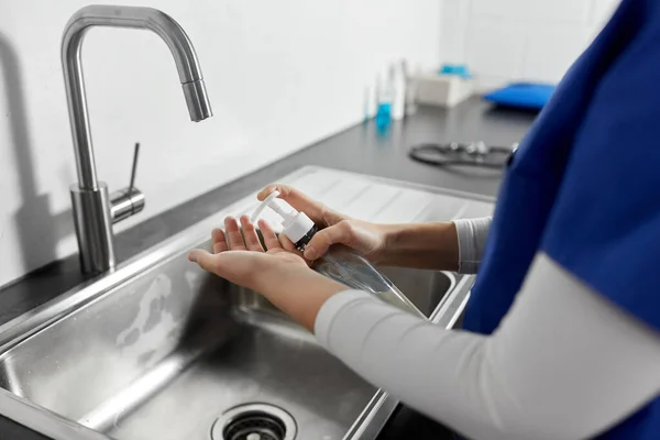 Läkare eller sjuksköterska tvätta händerna med flytande tvål — Stockfoto