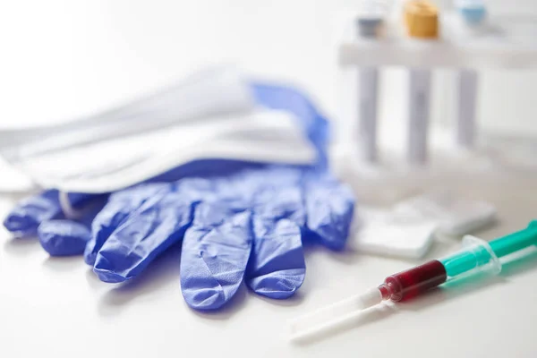 Zbliżenie krwi w strzykawce, rękawiczkach i masce — Zdjęcie stockowe