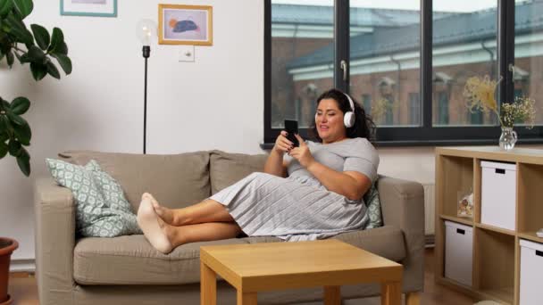 Mujer en auriculares escucha música en el teléfono inteligente — Vídeo de stock
