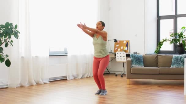 Vrouw doet springen jack oefening thuis — Stockvideo
