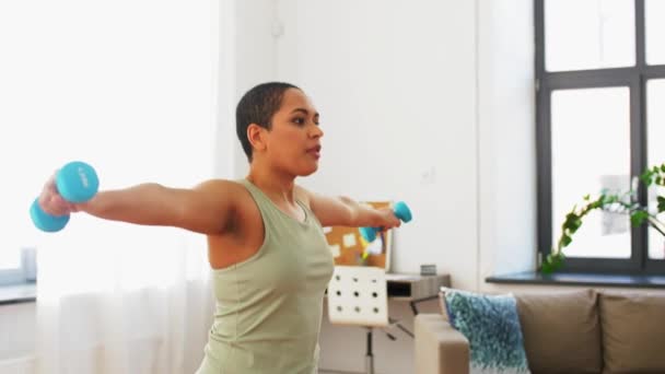 African woman with dumbbells exercising at home — Stock Video