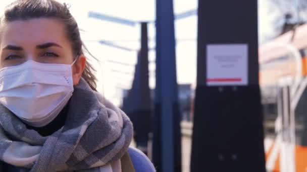 Mujer con mascarilla protectora en la estación de tren — Vídeo de stock