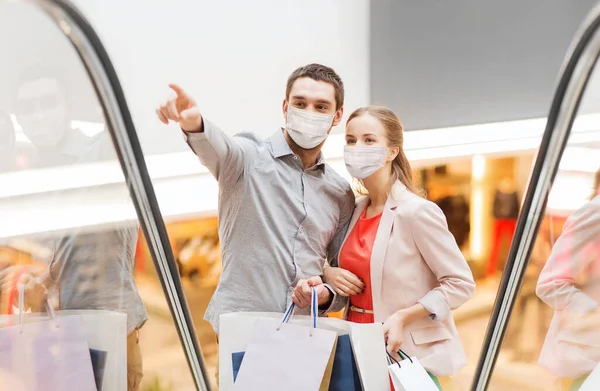 Feliz jovem casal com sacos de compras no shopping — Fotografia de Stock