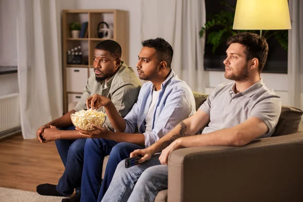 Amigos do sexo masculino com pipocas assistindo tv em casa — Fotografia de Stock