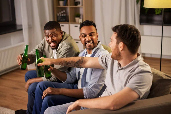Felizes amigos do sexo masculino beber cerveja em casa à noite — Fotografia de Stock