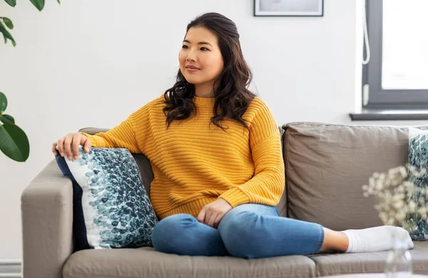 Ázsiai fiatal nő ül kanapén otthon — Stock Fotó