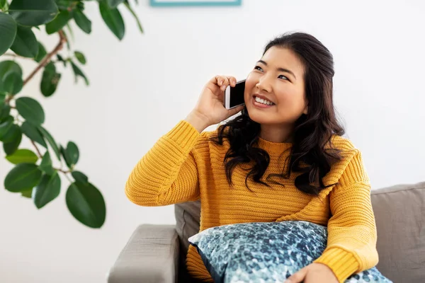 Gülümseyen Asyalı kadın evde akıllı telefondan arıyor. — Stok fotoğraf