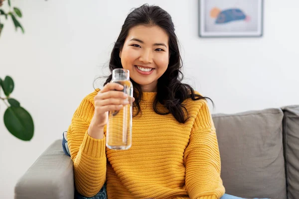 집에서 물을 마시고 있는 이시아 소녀의 웃는 모습 — 스톡 사진