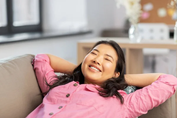 Femeie asiatică fericită întinsă pe canapea și visând — Fotografie, imagine de stoc