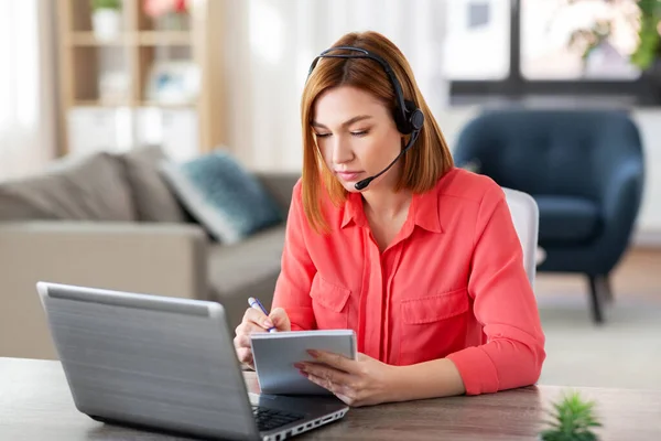 Mujer con auriculares y laptop trabajando en casa — Foto de Stock