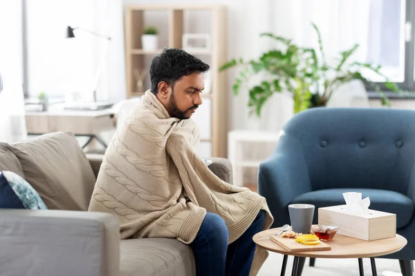 Beteg fiatalember takaróban forró teával otthon — Stock Fotó