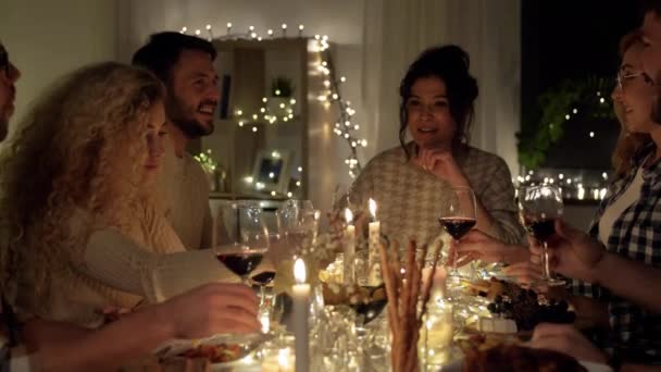 Gelukkig vrienden drinken rode wijn op kerstfeest — Stockvideo