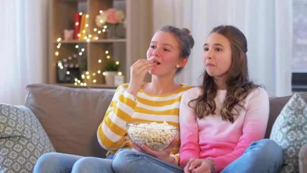 Meninas adolescentes comendo pipoca assistindo tv em casa — Vídeo de Stock