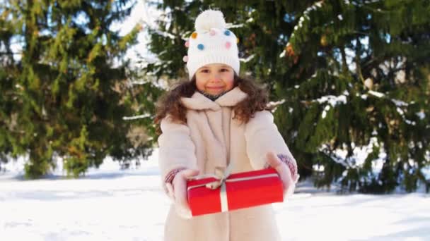 Chica feliz con regalo de Navidad en el parque de invierno — Vídeos de Stock