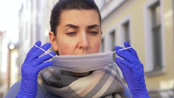 Jonge vrouw draagt beschermende gezichtsmasker in de stad — Stockvideo