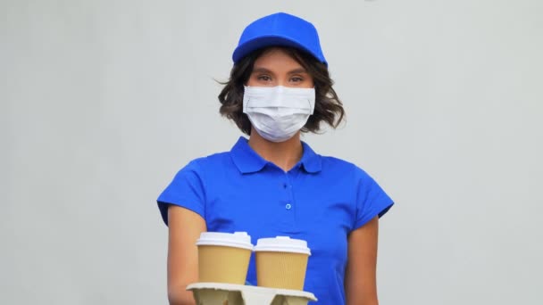 Vendedora en mascarilla facial con taza de café para llevar — Vídeos de Stock