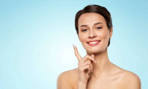 Young woman with moisturizing cream on finger — Stock Photo, Image