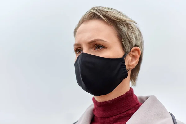 Nainen yllään suojaava uudelleenkäytettävä este naamio — kuvapankkivalokuva