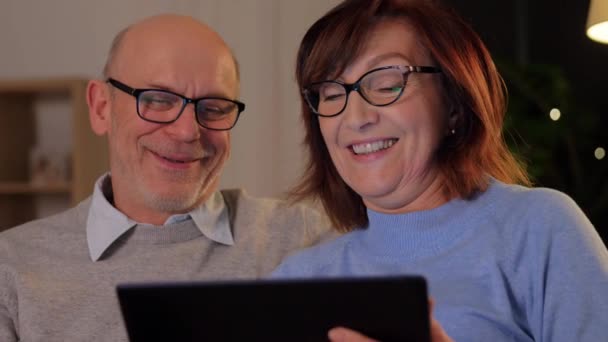 Happy senior couple with tablet pc at home — Stock Video