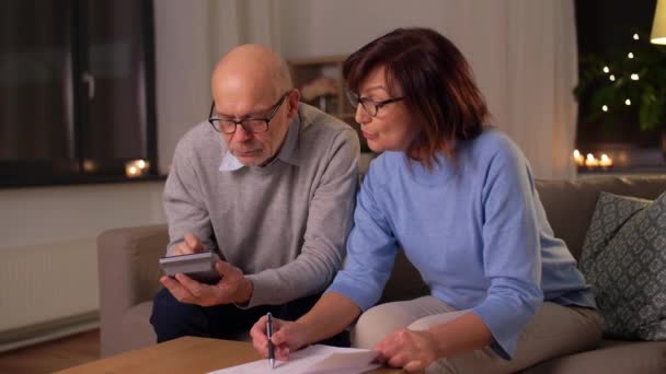 Senior couple with papers and calculator at home — Stock Video