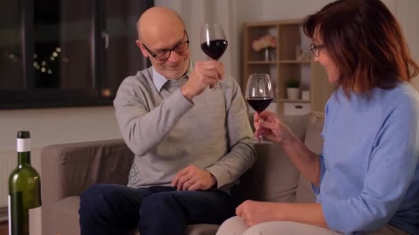 Feliz pareja de ancianos bebiendo vino tinto en casa — Vídeos de Stock