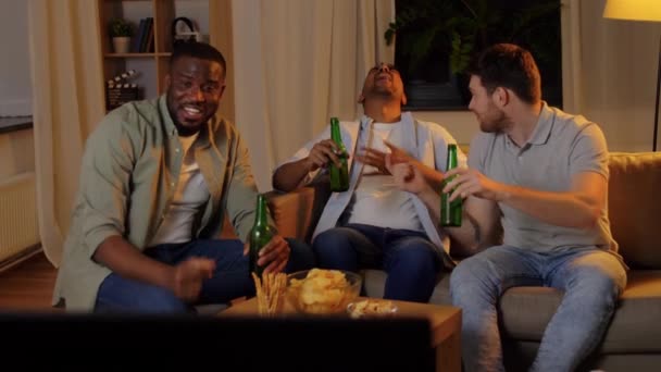 Mężczyźni przyjaciele pijący piwo i oglądający telewizję w domu — Wideo stockowe