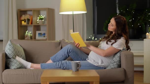 Gelukkig glimlachen zwangere vrouw lezen boek thuis — Stockvideo