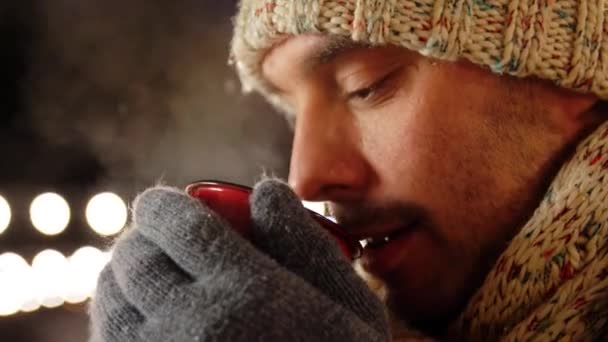 Happy young man drinking tea outdoors in winter — Stock Video