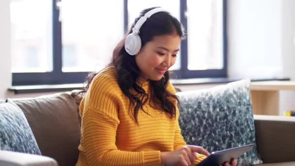 Feliz asiático mujer en auriculares escuchando música — Vídeo de stock