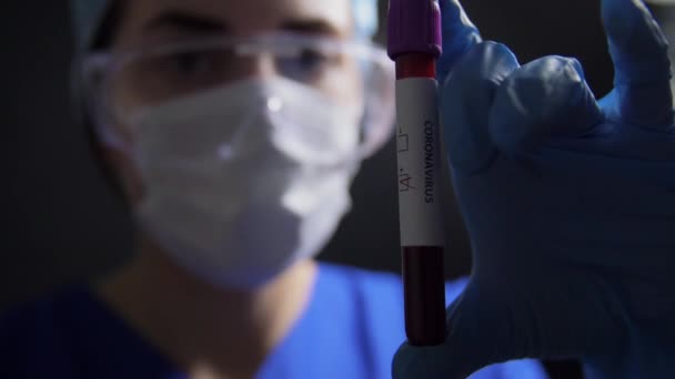 Доктор держит стакан с коронавирусом крови — стоковое видео