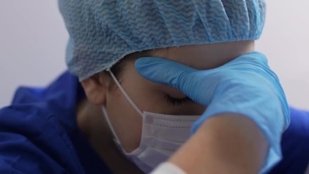 Müder Arzt oder Krankenschwester mit Mundschutz, Handschuhen und Mütze — Stockvideo