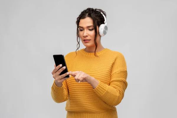 Femme dans les écouteurs avec smartphone — Photo